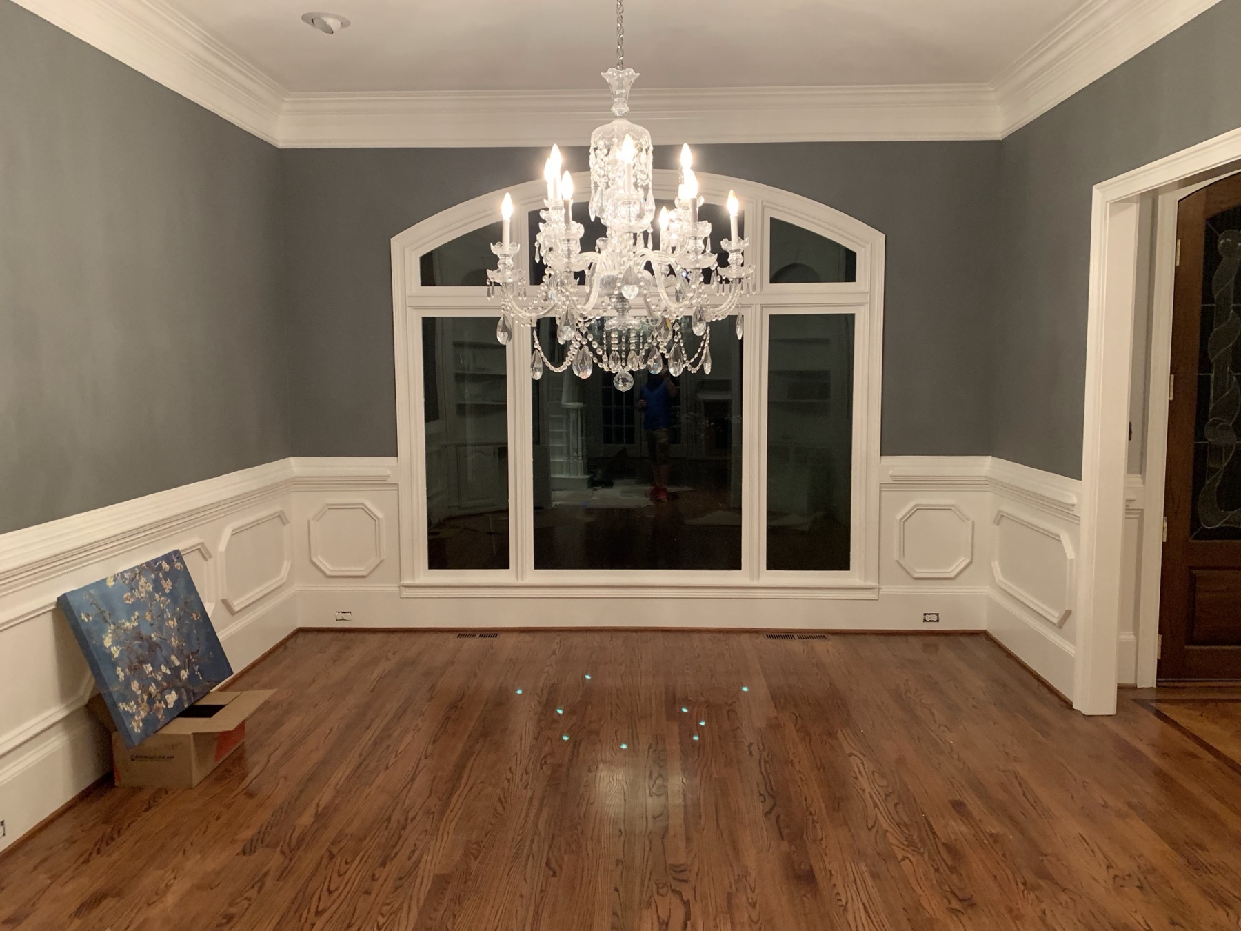 Formal dining room with gray walls and white wainscoting