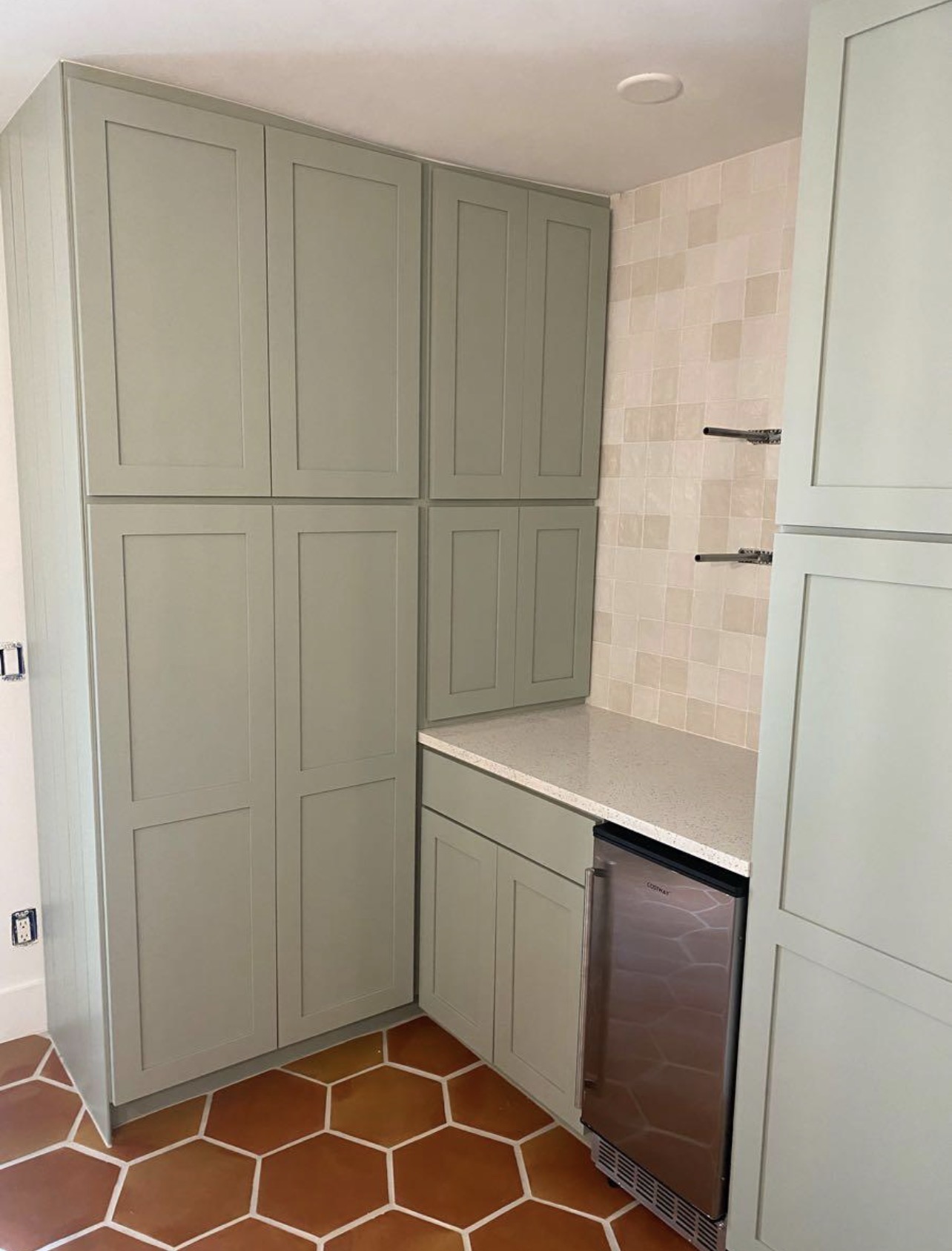 Floor-to-ceiling sage green pantry cabinets
